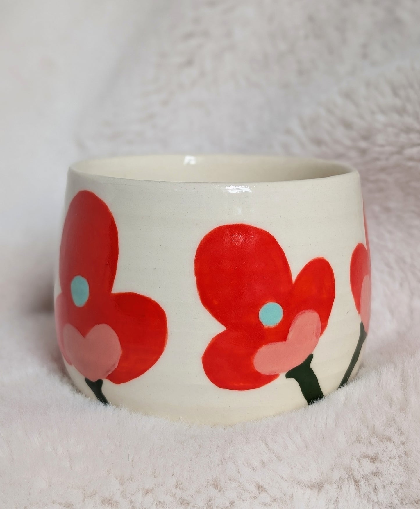 Ceramic bowl with red coral floral design on a white background