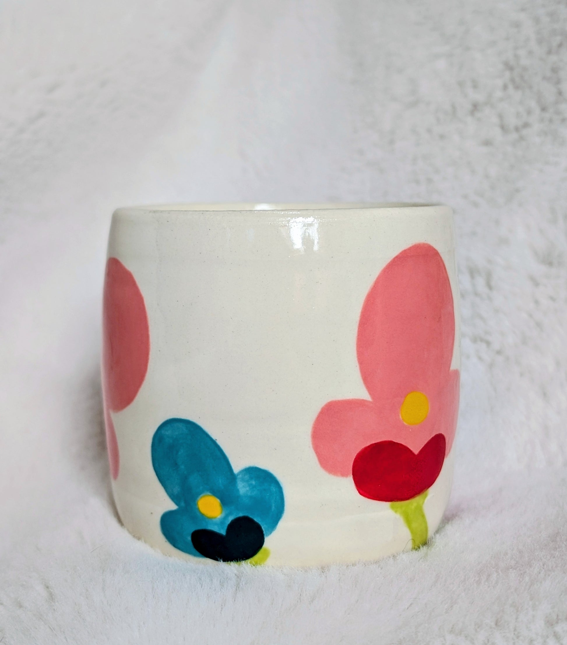 Ceramic mug with colorful floral designs on a white background