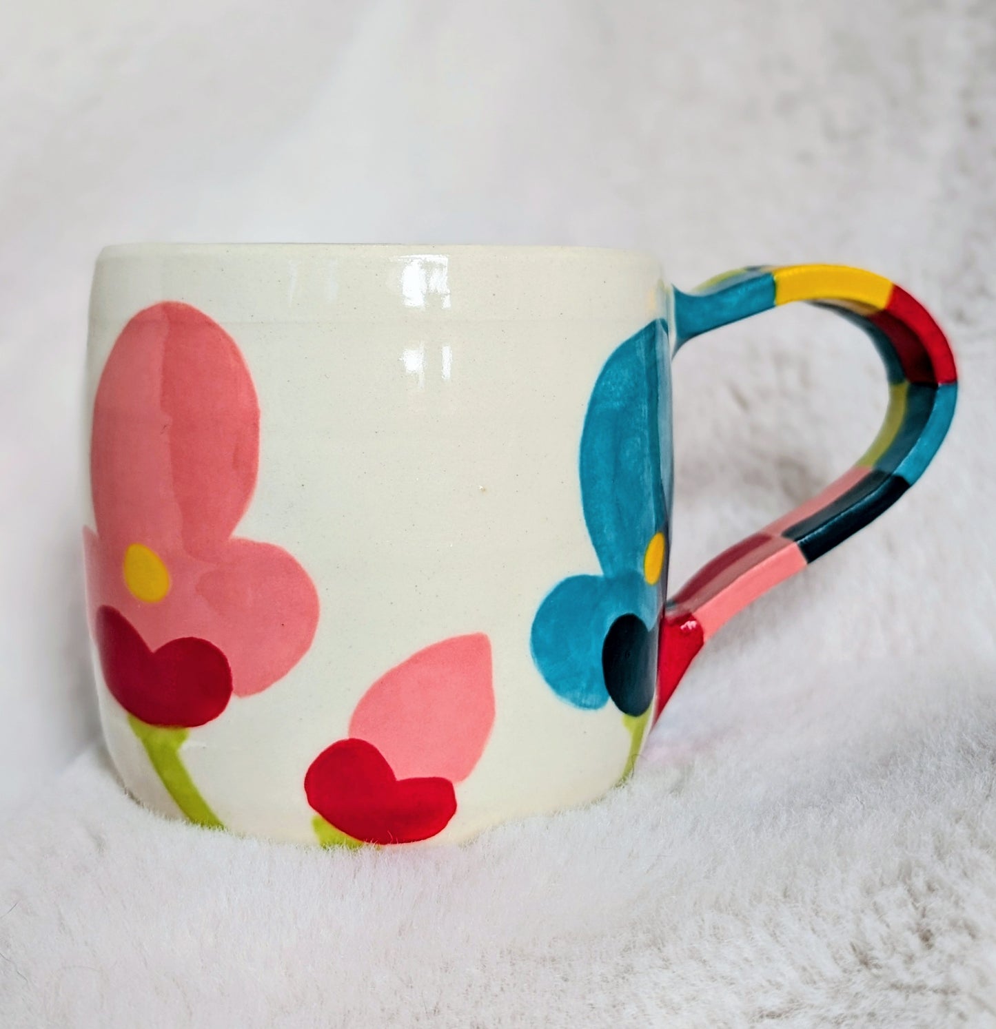 Colorful mug with floral design on a white background