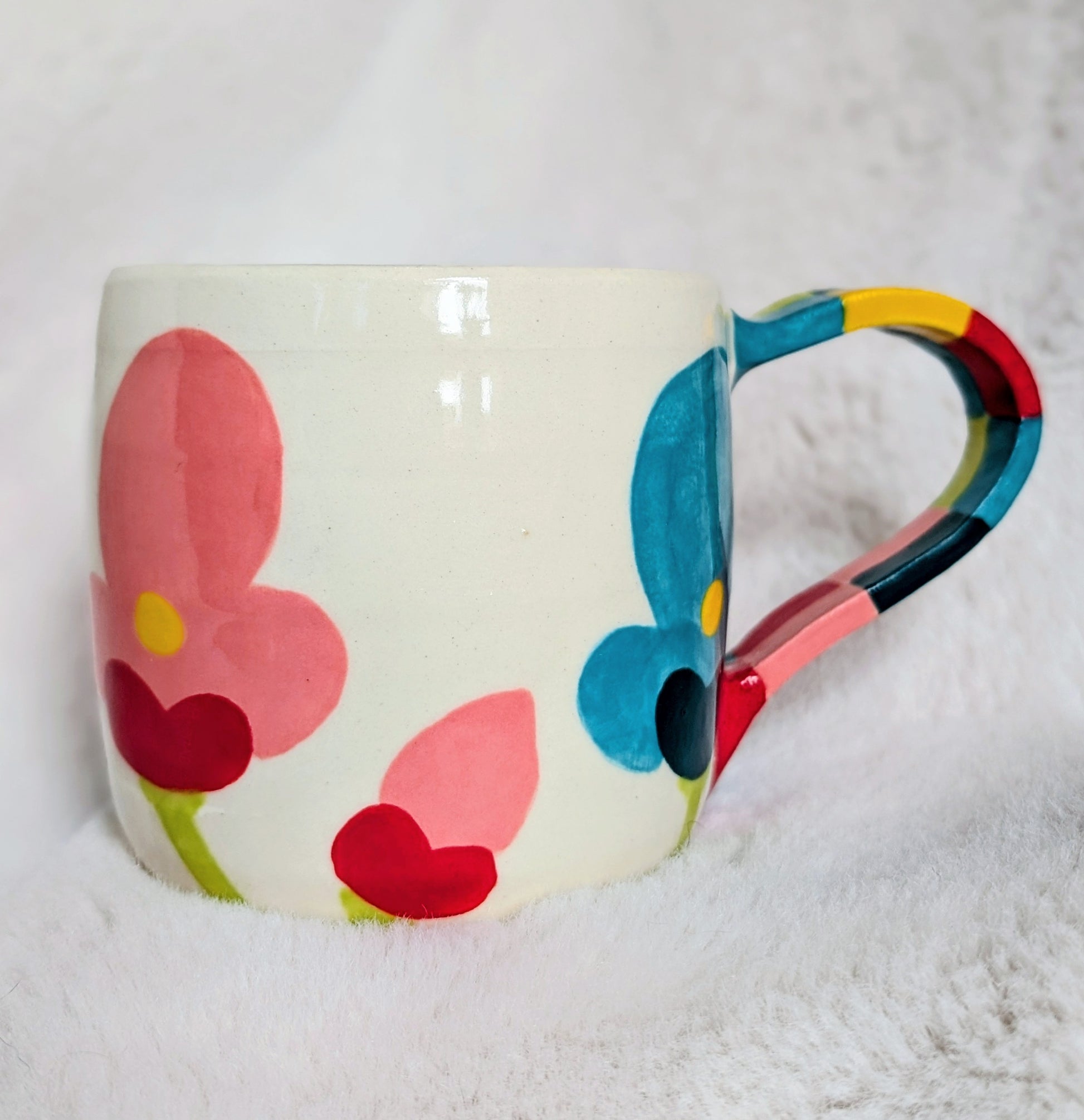 Colorful mug with floral design on a white background