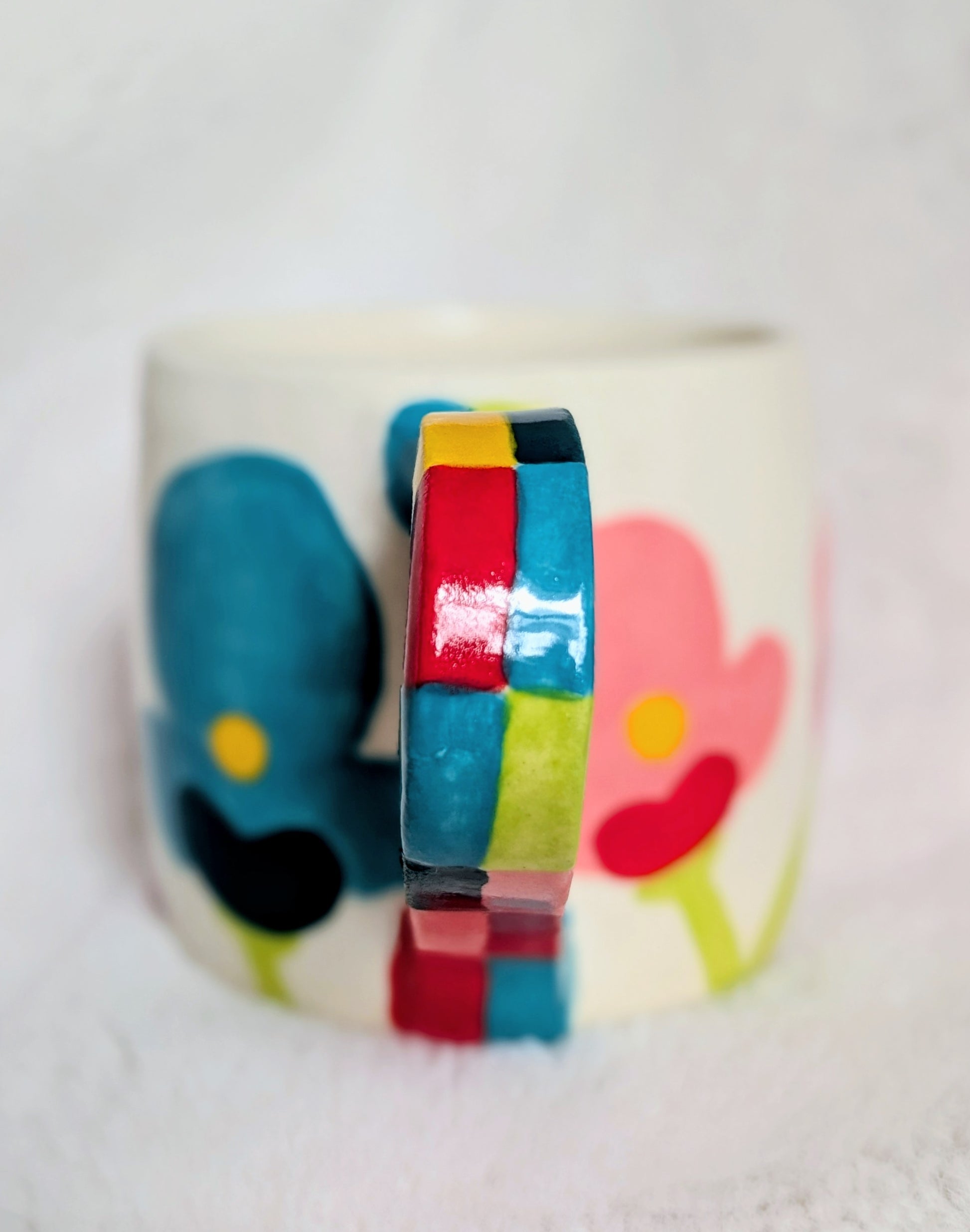 Colorful ceramic mug with abstract design on a white background